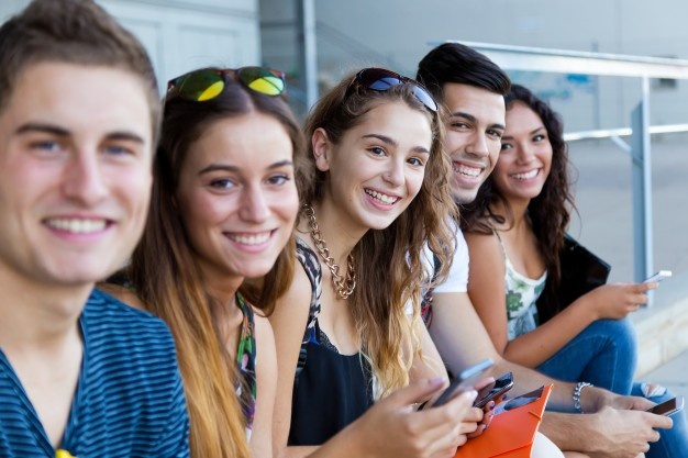 group-students-having-fun-with-smartphones-after-class_1301-4411
